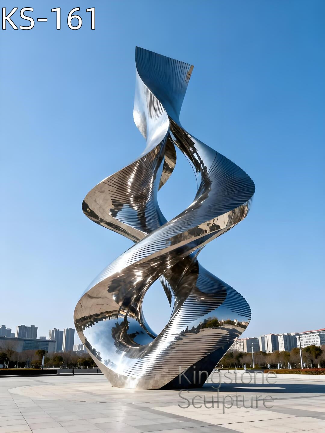 A monumental Kingstone KS-157 mirror polished stainless steel dual-flame sculpture installed in a luxury garden setting, reflecting the surrounding trees and sky.